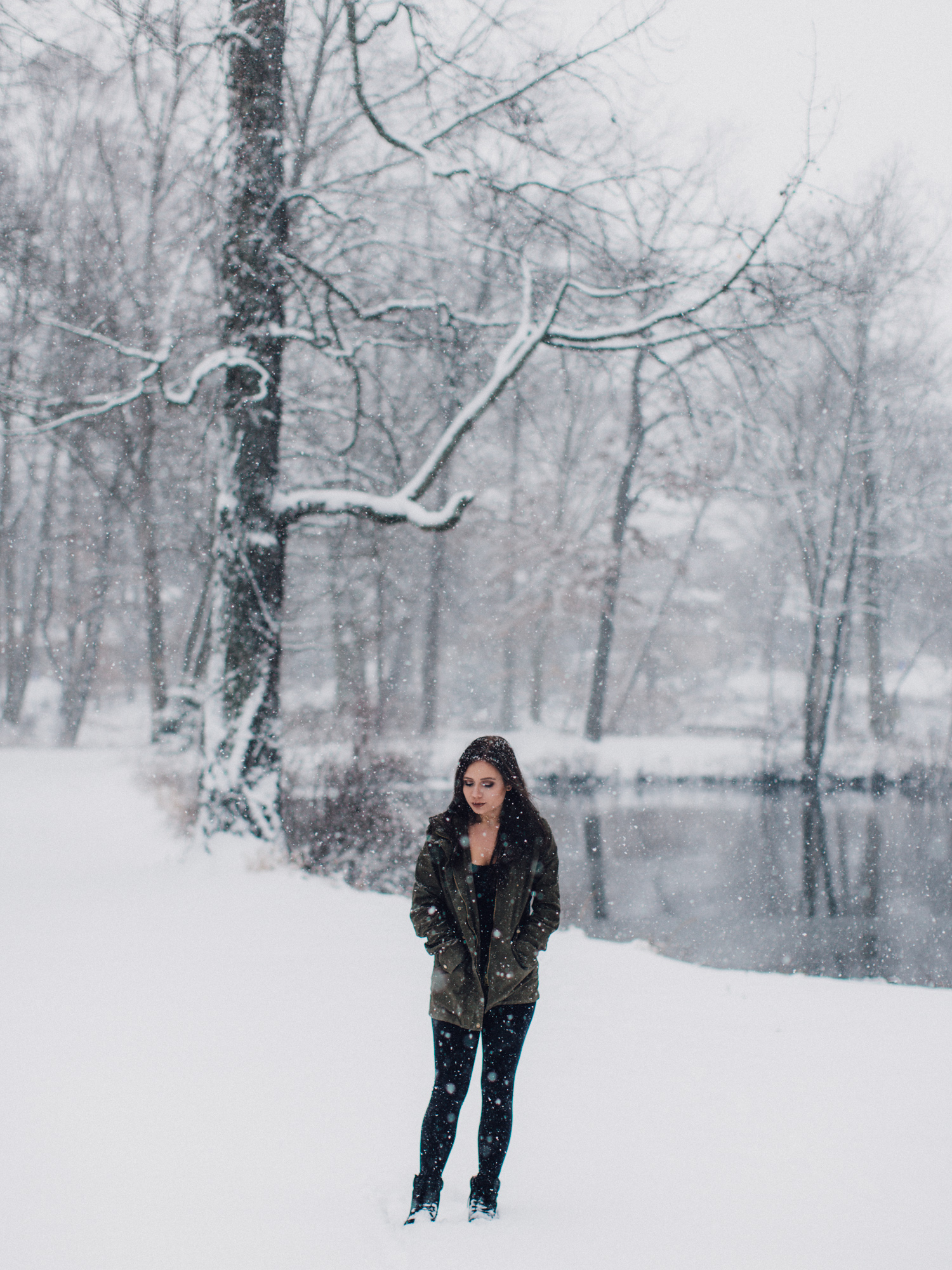 Woman standing among snow-covered trees